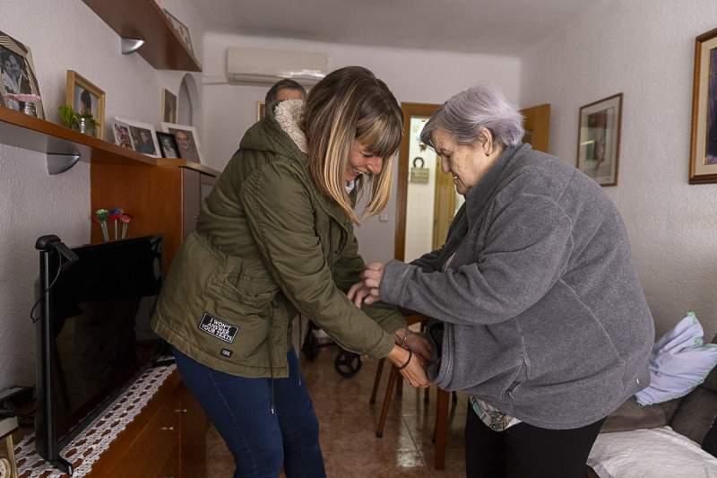 Profesional de atención a la dependencia asistiendo a una persona mayor tras la aprobación de la nueva financiación estatal del sistema.